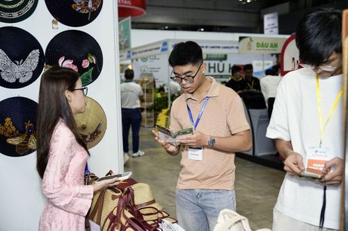 Khách quốc tế và trong nước tìm hiểu các sản phẩm công nghiệp nông thôn được trưng bày tại triển lãm.