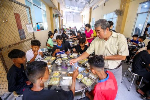 Thầy Lê Minh Trung kiểm tra từng bàn ăn, rà soát các điều kiện phục vụ học sinh tại nhà ăn nội trú. Ảnh: Giang Phương - TTXVN