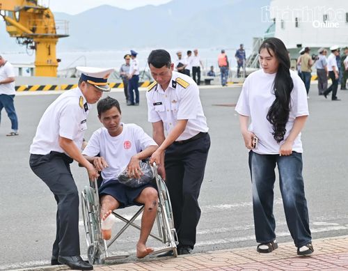 Cán bộ Vùng 4 Hải quân hỗ trợ ngư dân Đỗ Văn Tự di chuyển vào nơi tiếp đón.