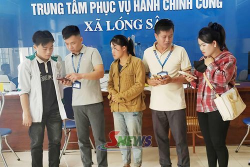 Công chức Trung tâm Phục vụ hành chính công xã Lóng Sập hướng dẫn nhân dân nộp hồ sơ trực tuyến.