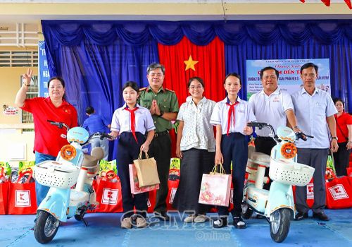 Hai học sinh Trường THCS Trần Huỳnh có hoàn cảnh đặc biệt khó khăn được trao tặng xe đạp điện.