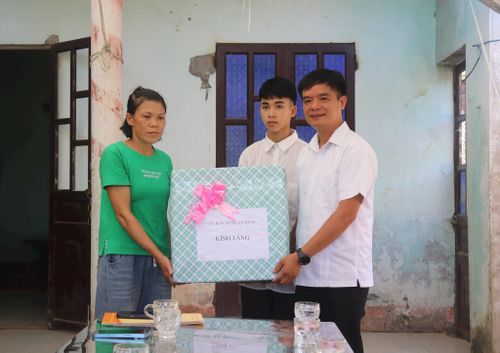 Chủ tịch Ủy ban MTTQ Việt Nam xã Ba Vì Đỗ Văn Minh trao quà hỗ trợ cho gia đình em Mai Dương Anh Thắng. Ảnh: Hiền Chi