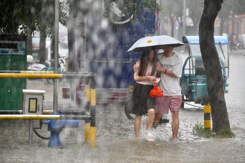 Người dân đi bộ dọc theo một con phố ngập nước giữa cơn mưa lớn ở Phúc Châu, tỉnh Phúc Kiến, Trung Quốc, ngày 3/9, sau khi bão Saudel đổ bộ lần thứ ba. Ảnh: Reuters. 