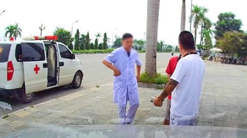 Hình ảnh chiếc xe cấp cứu và người mặc đồ nhân viên y tế liên quan vụ việc người nhà phản ảnh lên mạng xã hội. Ảnh cắt từ clip