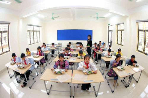 Giờ ăn trưa tại lớp học của Trường phổ thông nội trú Tiểu học và Trung học cơ sở Yên Sơn mới được khánh thành. Ảnh: Quang Quyết - TTXVN