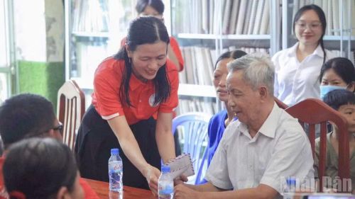 Cô Nguyễn Thị Minh Tâm trao quà cho những hoàn cảnh khó khăn. (Ảnh: LÝ OANH)