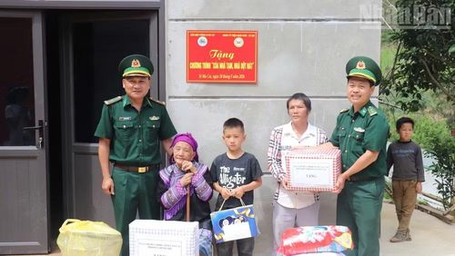 Cán bộ, chiến sĩ Đồn Biên phòng Si Ma Cai tặng quà cho hộ gia đình bà Vàng Thị Mai.