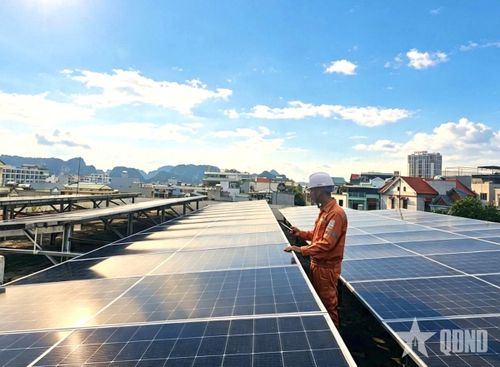 Nhân viên kiểm tra tấm pin điện mặt trời mái nhà tại trụ sở Công ty Điện lực Quảng Ninh. Ảnh: XUÂN ANH
