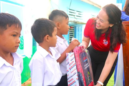  Bà Lê Thị Hồng Nhung trao quà cho các em học sinh. Ảnh: TIẾN THẮNG 