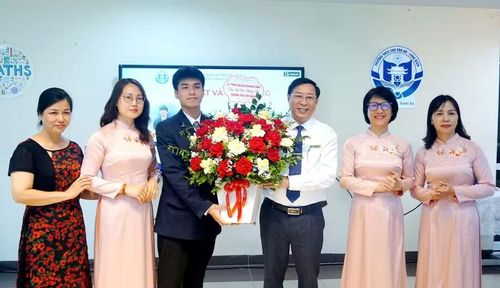Thầy Tuấn nhận hoa tri ân từ em Nguyễn Nhật Minh, lớp 11 chuyên Lý, Trường THPT chuyên Khoa học Tự nhiên, Đại học Quốc gia Hà Nội giành Huy chương Vàng tại Olympic Vật lý quốc tế 2026. Ảnh NTCC.