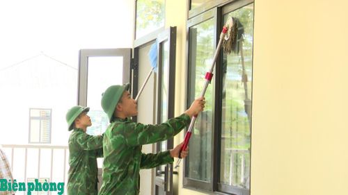 Cán bộ, chiến sỹ Bộ đội Biên phòng tỉnh Hà Tĩnh giúp Trường Phổ thông nội trú Tiểu học và Trung học cơ sở Hương Khê vệ sinh phòng học. Ảnh: Thế Mạnh