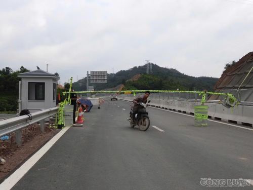 Người dân cố tình vượt rào chắn đi vào cao tốc đang thi công.