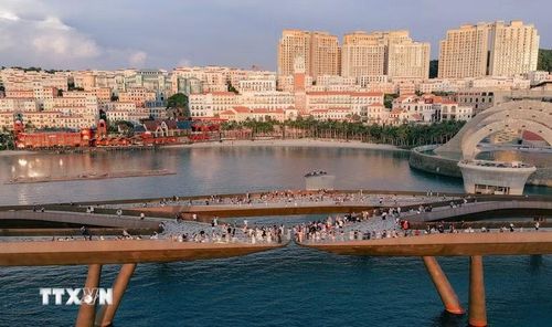 Du khách chụp ảnh lưu niệm, chờ ngắm hoàng hôn trên Cầu Hôn, Đặc khu Phú Quốc. (Ảnh: TTXVN phát)