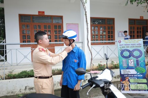Cán bộ Phòng Cảnh sát giao thông, Công an tỉnh, hướng dẫn đội mũ bảo hiểm đúng quy cách cho học sinh Trường Phổ thông dân tộc nội trú THCS&THPT Chi Lăng