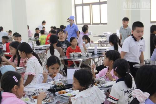 Các em học sinh thực hiện việc ăn uống trong phòng ăn sạch sẽ, bảo đảm. (Ảnh: QUỐC ĐẠT)
