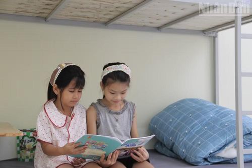 Các em học sinh đọc sách mới trong phòng ký túc xá. (Ảnh: QUỐC ĐẠT)