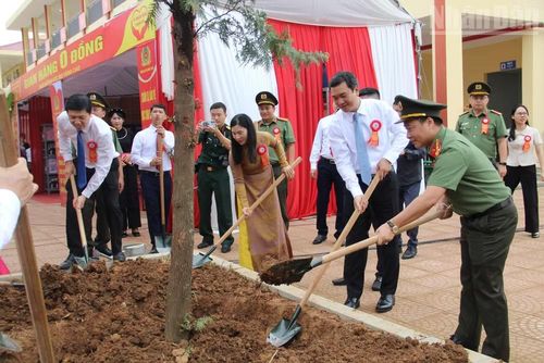 Các đại biểu tham gia trồng cây trong khuôn viên nhà trường. (Ảnh: QUỐC ĐẠT)
