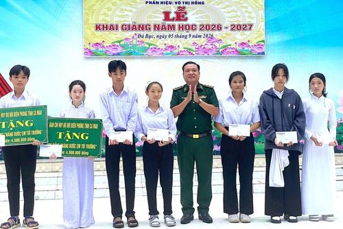 Trung tá Trương Văn Kết, Chính trị viên Đồn Biên phòng Sông Đốc tặng học bổng cho các em học sinh Trung học cơ sở và Trung học phổ thông Khánh Hưng (xã Đá Bạc, tỉnh Cà Mau). (Ảnh: HOÀNG TÁ)