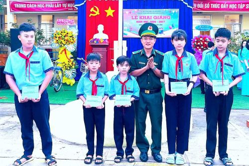 Đại diện Đồn Biên phòng Gành Hào tặng học bổng cho các em học sinh trường Trung học cơ sở Lê Hồng Phong (xã Gành Hào, tỉnh Cà Mau). (Ảnh: HOÀNG TÁ)