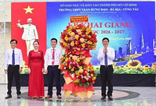  Đồng chí Võ Văn Minh tặng hoa chúc mừng lễ khai giảng tại Trường THPT Trần Hưng Đạo. Ảnh: NGUYỄN NAM 