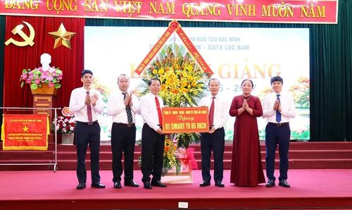 Ông Mai Sơn tặng hoa, quà chúc mừng Ban lãnh đạo Trung tâm GDNN-GDTX Lục Nam.