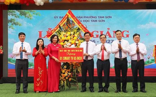 Ông Lê Xuân Lợi (thứ 4 từ phải sang trái) tặng hoa và quà cho Trường Tiểu học Tam Sơn.