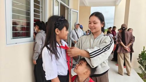 Siu H Atysa chỉnh lại chiếc khăn quàng đỏ cho người em lớp 4.