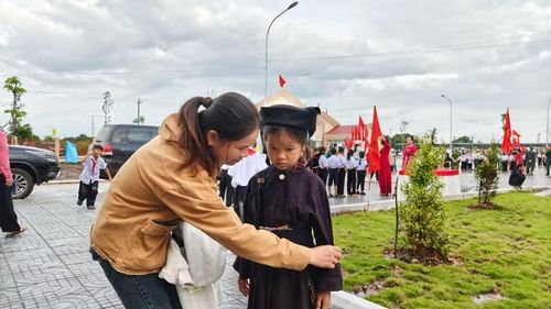Chị Phạm Thị Tâm chỉnh sửa trang phục cho con.