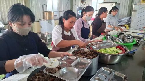 Đội ngũ nhân viên cấp dưỡng của trường phục vụ học sinh ăn trưa.