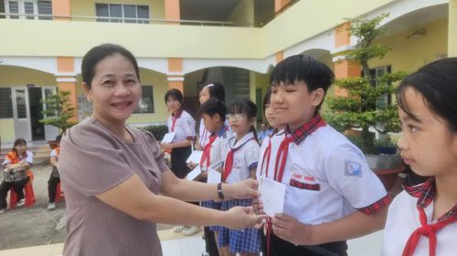 Các đại biểu trao quà động viên học sinh có hoàn cảnh khó khăn tại lễ khai giảng.