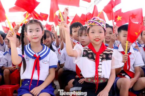  Em Lê Thị Thuỳ Chi (bìa phải) phấn khởi khi được dự lễ khai giảng trong ngôi trường mới khang trang, sạch đẹp. 