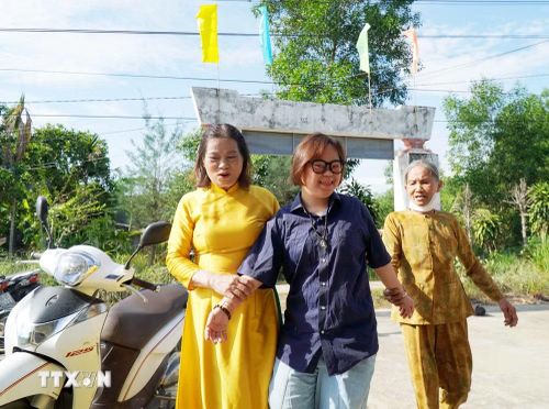 Thầy cô, người thân dìu các em khuyết tật vào dự lễ khai giảng. (Ảnh: Lê Phước Ngọc/TTXVN)