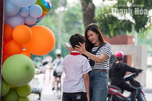 Phụ huynh tranh thủ chỉnh lại trang phục, chăm chút cho con trước khi bước vào sân trường.
