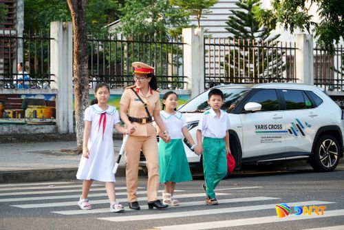 Cảnh sát giao thông hỗ trợ đưa học sinh sang đường. Ảnh: HỒ QUÂN