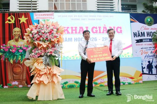 Ủy viên Ban Thường vụ Thành ủy, Trưởng ban Tuyên giáo và Dân vận Thành ủy Dương Minh Dũng trao 30 suất học bổng của Thành ủy, HĐND, UBND, Ủy ban MTTQ Việt Nam thành phố Đồng Nai cho nhà trường. Ảnh: Hải Quân