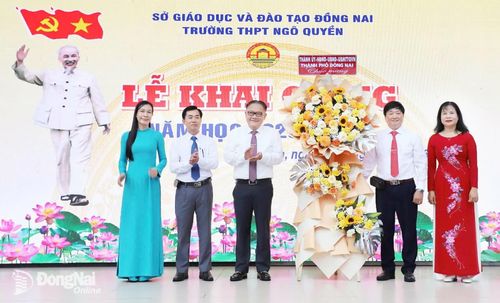Ủy viên Ban Thường vụ Thành ủy, Phó Chủ tịch Thường trực UBND thành phố Nguyễn Kim Long trao tặng lẵng hoa chúc mừng của Thành ủy, HĐND, UBND, Ủy ban MTTQ Việt Nam thành phố Đồng Nai cho Trường THPT Ngô Quyền. Ảnh: My Ny