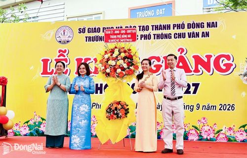 Ủy viên Ban Thường vụ Thành ủy, Giám đốc Sở Tài chính Trương Thị Hương Bình tặng lẵng hoa của Thành ủy, HĐND, UBND, Ủy ban MTTQ Việt Nam thành phố chúc mừng Trường THPT Chu Văn An. Ảnh: Kim Liễu
