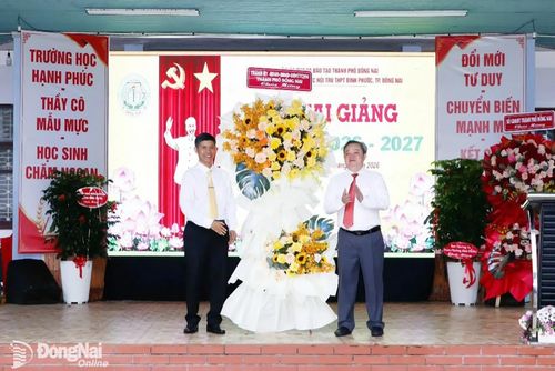 Ủy viên Ban Thường vụ Thành ủy, Trưởng ban Nội chính Thành ủy Nguyễn Minh Hợi trao học bổng và tặng lẵng hoa chúc mừng của Thành ủy, HĐND, UBND, Ủy ban MTTQ Việt Nam thành phố cho Trường Phổ thông Dân tộc nội trú THPT Bình Phước. Ảnh: Thổ Tín