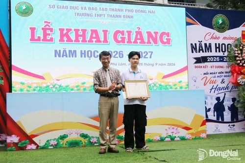 Bí thư Đảng ủy, Chủ tịch HĐND xã Phú Lâm Nguyễn Hữu Ký khen thưởng cho em Đào Thiên Ân, thủ khoa khối A00 của thành phố Đồng Nai trong kỳ thi tốt nghiệp THPT năm 2026. Ảnh: Hải Quân