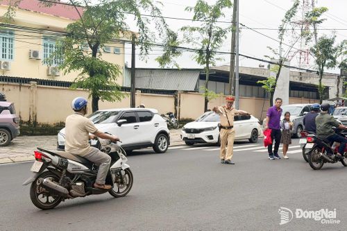 Đội CSGT đường bộ số 4, Phòng CSGT Công an thành phố Đồng Nai điều tiết giao thông tại Trường tiểu học Tân Phú (phường Bình Phước). Ảnh: Quang Minh