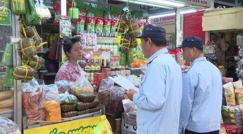 Kiểm tra việc niêm yết giá của tiểu thương. Ảnh: Văn Chinh