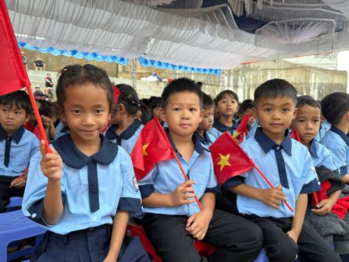 Học sinh trong bộ đồng phục mới phấn khởi dự lễ khai giảng đầu tiên tại ngôi trường mới
