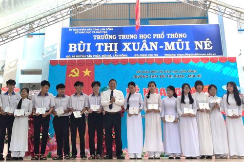 Ông Phạm Văn Nam, Ủy viên Ban Thường vụ Tỉnh ủy, Bí thư Đảng ủy, Chủ tịch HĐND phường Mũi Né trao các phần quà động viên học sinh khó khăn của Trường THPT Bùi Thị Xuân - Mũi Né trong năm học mới