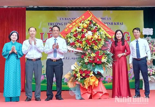 Đồng chí Đào Đình Tùng, Ủy viên Ban Thường vụ Tỉnh ủy, Bí thư Đảng ủy, Chủ tịch HĐND phường Phủ Lý và đồng chí Lê Nguyên Ngọc, Tỉnh ủy viên, Giám đốc Sở Văn hóa và Thể thao tặng hoa chúc mừng nhà trường. Ảnh: Tiến Đoàn