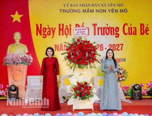 Đồng chí Bùi Thị Thu Hiền, Bí thư Đảng uỷ, Chủ tịch HĐND xã Yên Mô tặng hoa chúc mừng nhà trường. Ảnh: Ngọc Linh