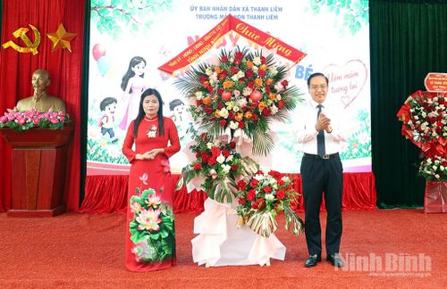 Đồng chí Đặng Thanh Sơn, Ủy viên Ban Thường vụ Tỉnh ủy, Phó Chủ tịch UBND tỉnh tặng hoa chúc mừng cô, trò Trường Mầm non Thanh Liêm tại Lễ khai giảng năm học mới. Ảnh: Phạm Hiền