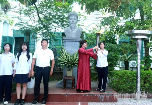 Hiệu trưởng Trường THPT B Nguyễn Khuyến trao ngọn đuốc truyền thống cho học sinh, gửi gắm niềm tin và khát vọng tiếp nối truyền thống hiếu học của nhà trường. Ảnh: Hồng Ngọc