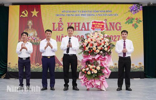 Đại diện Thường trực Đảng ủy xã Bình Sơn tặng hoa chúc mừng thầy và trò Trường THPT A Nguyễn Khuyến. Ảnh: Trần Thoan