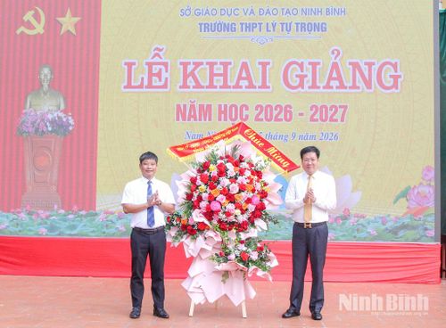 Đồng chí Lê Xuân Huy, Tỉnh ủy viên, Phó Chủ tịch HĐND tỉnh tặng hoa chúc mừng nhà trường nhân dịp năm học mới. Ảnh: Hoa Xuân