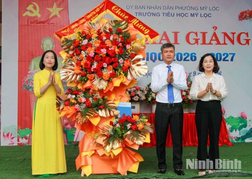 Các đồng chí: Phạm Duy Hưng, Uỷ viên Ban Thường vụ Tỉnh uỷ, Chánh Văn phòng Tỉnh uỷ; Hoàng Thị Hoài Phương, Tỉnh uỷ viên, Phó Giám đốc Báo và phát thanh, truyền hình Ninh Bình tặng Trường Tiểu học Mỹ Lộc lẵng hoa tươi thắm. Ảnh: Trần Hồng Minh